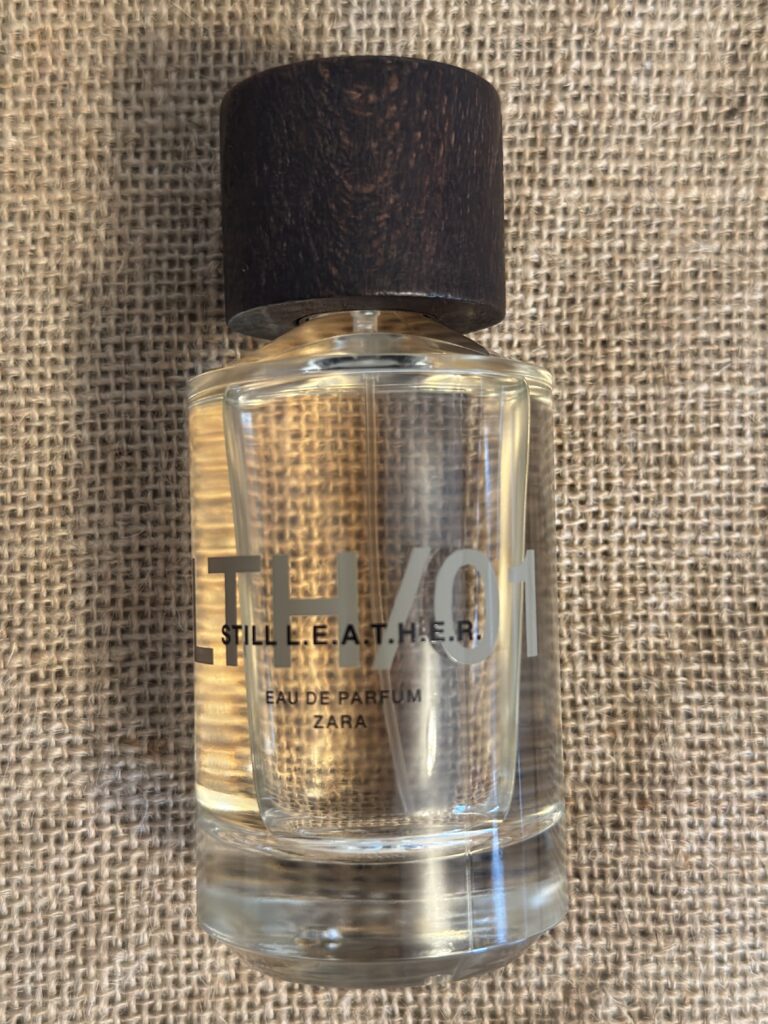 Zara Still Leather fragrance bottle styled on coffee sack creating raw leather inspired aesthetic