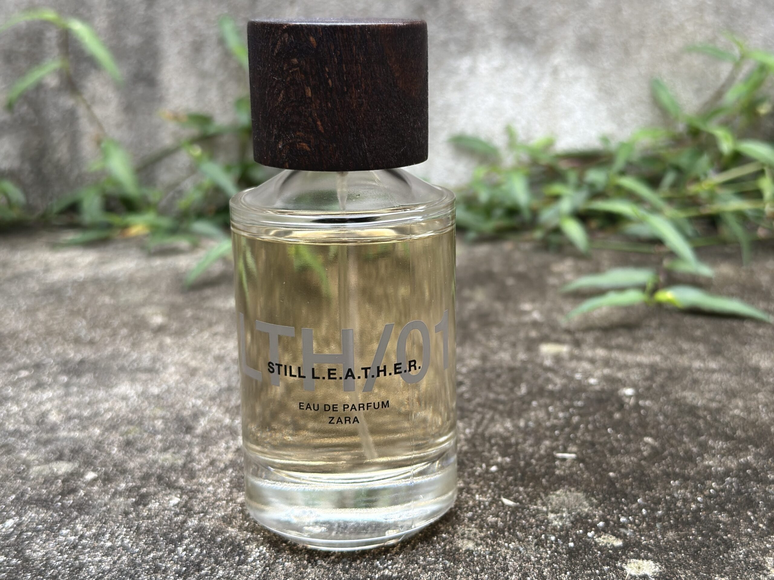 Zara Still Leather perfume bottle photographed outdoors in natural light, capturing the fresh yet rugged character of the fragrance presentation.