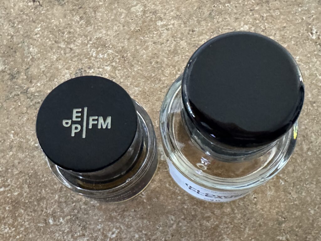 Top view of Frederic Malle Carnal Flower and Zara Flower Please perfume bottles on a table