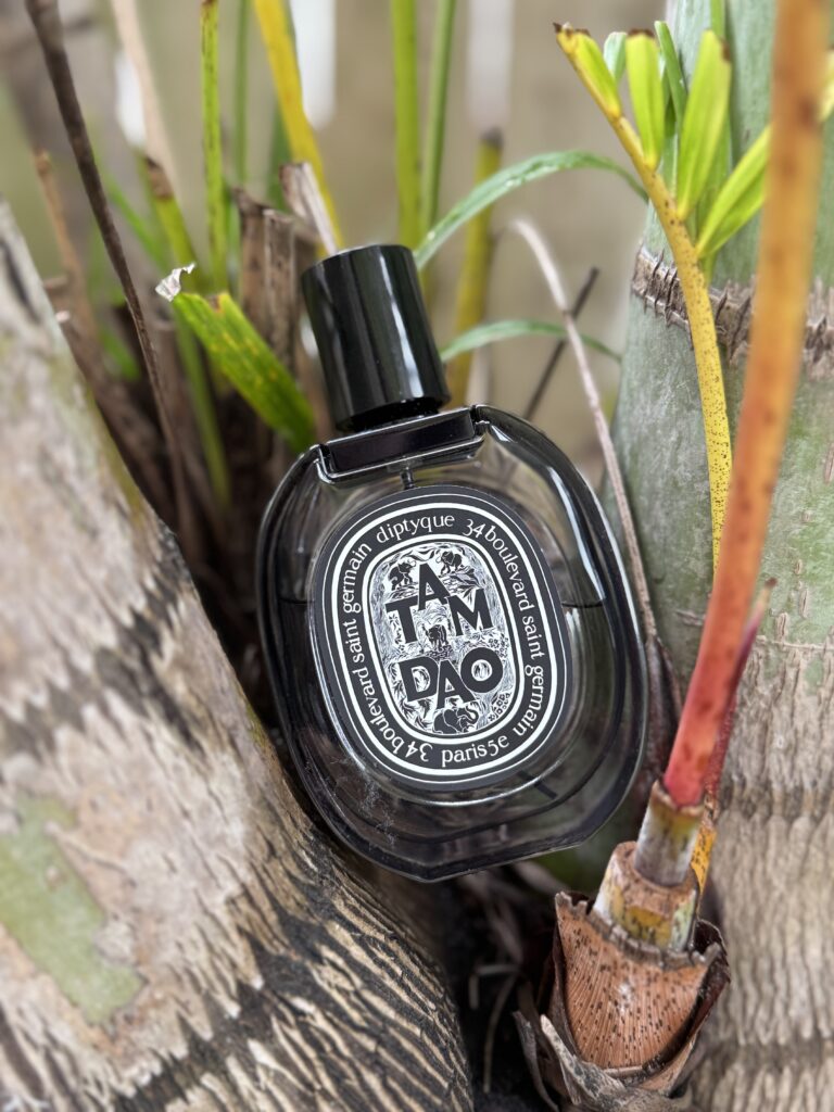Diptyque Tam Dao EDP bottle photographed with natural wood background